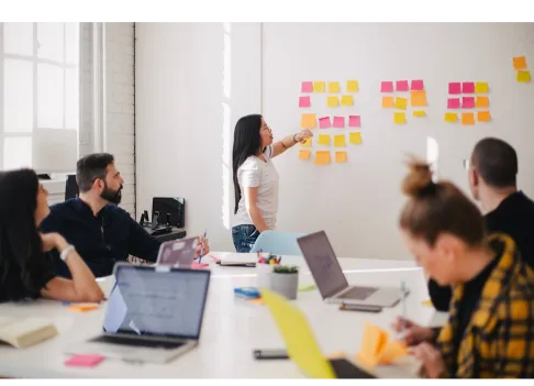 Meeting with 5 persons, one of them presenting their UX results on a white dashboard